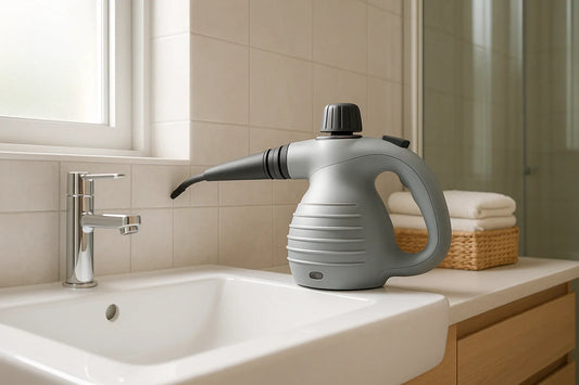 Handheld steam cleaner nozzle touching grout lines on bathroom tile near sink and glass shower door in a bright modern bathroom